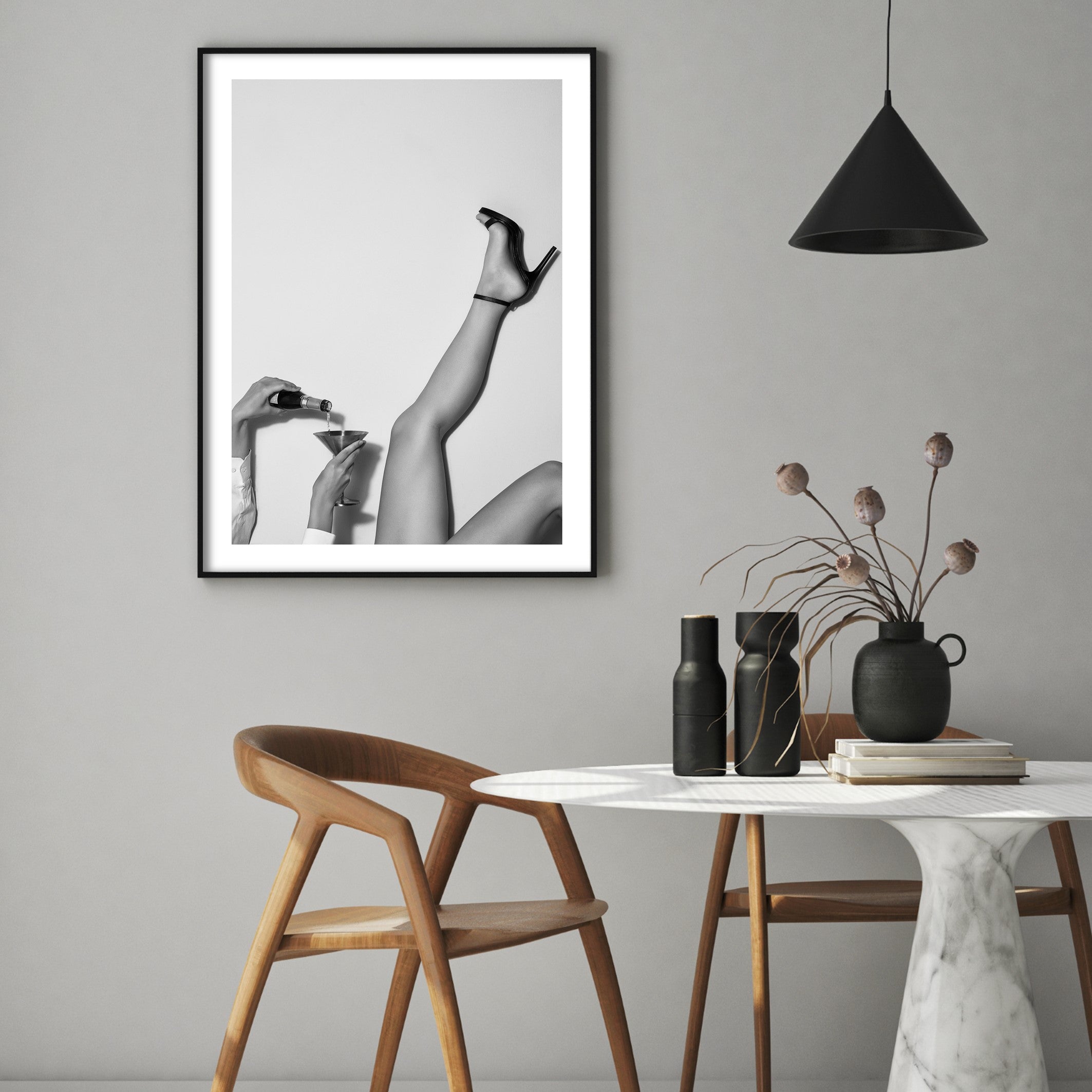 black and white poster of woman in heels pouring a drink in a boho style kitchen