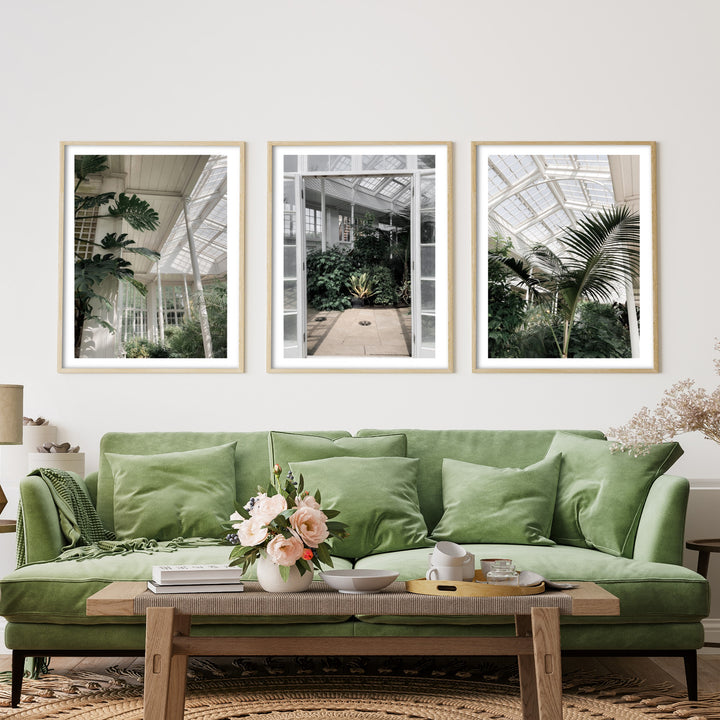 botanical wall art posters above a velvet green sofa